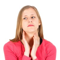 Unhappy woman with thyroid gland pain.